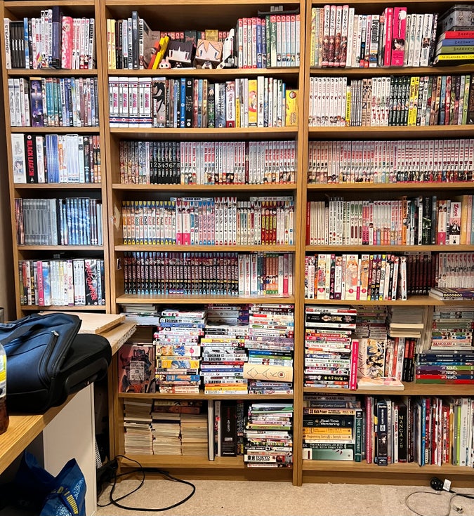 My bookshelf at my mums house, overflowing with manga volumes 